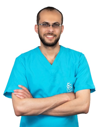 A person wearing a blue scrubs and glasses
Description automatically generated
